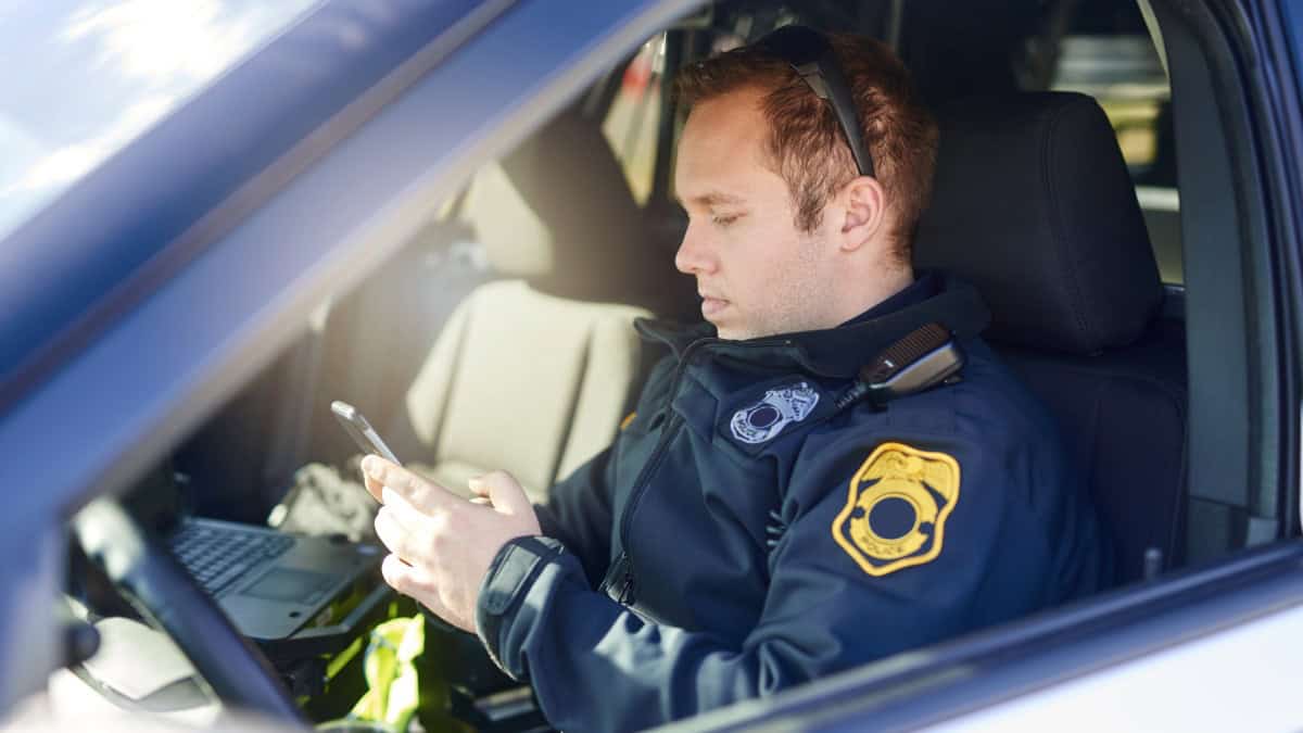 Security guard checking phone inside patrol vehicle in Nashville.
