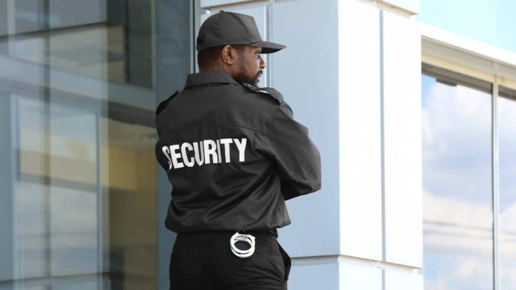 Security guard in uniform with "SECURITY" on back, providing event security services.