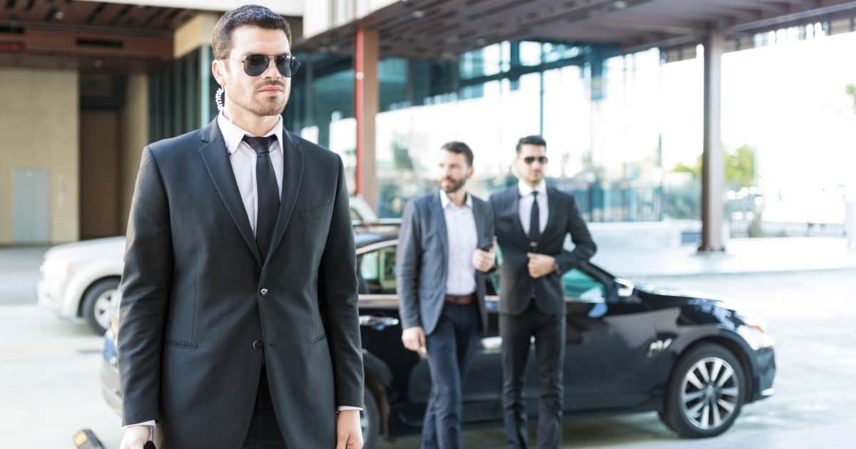 Professional security team in suits providing security services outside a modern building.