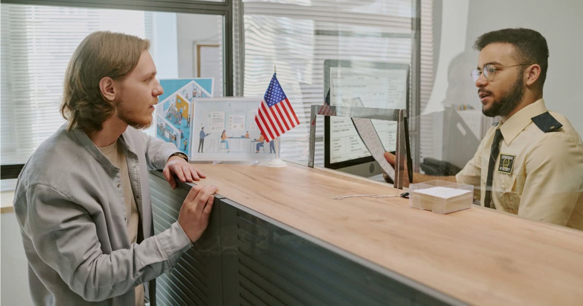Customer consulting with security officer at Freeman Protective Services reception desk.